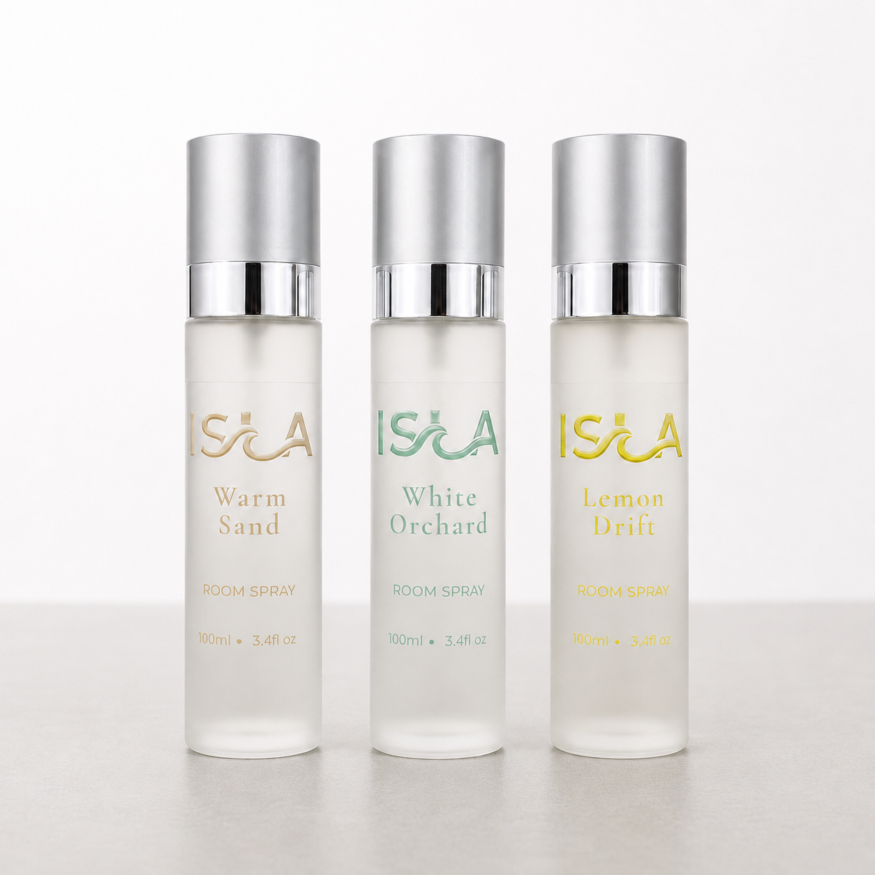 Three ISLA room spray bottles on a white background on stone