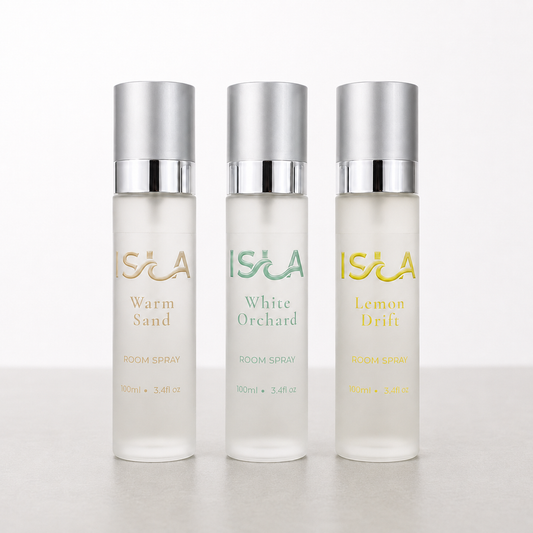 Three ISLA room spray bottles on a white background on stone