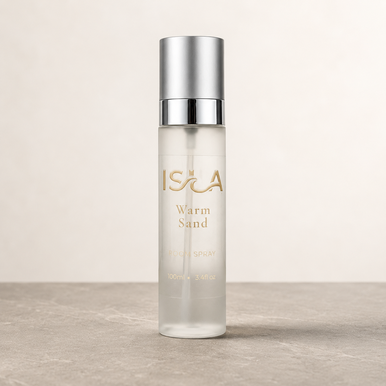 Clear bottle labeled 'Isla' with 'Warm Sand' on a neutral background stone surface