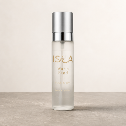 Clear bottle labeled 'Isla' with 'Warm Sand' on a neutral background stone surface